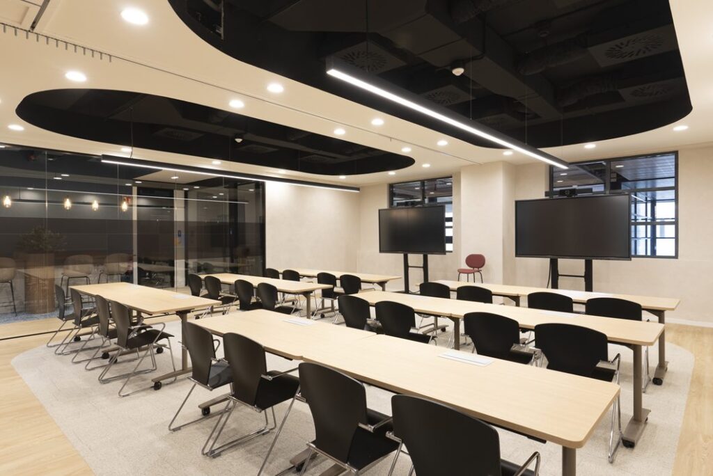 Sala de formación con mesas y pantallas, business coworking en Diagonal Barcelona