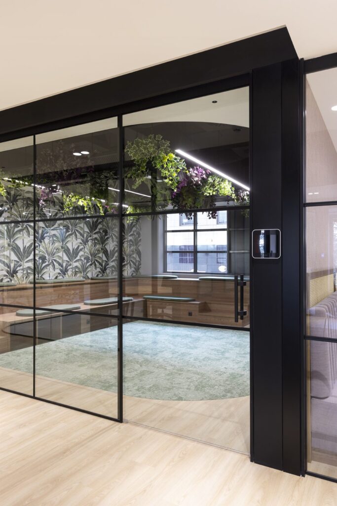 Sala acristalada con zona chill-out, servicios de un coworking moderno